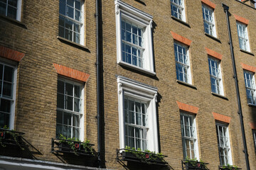 Fototapeta na wymiar Sunlit brick buildings on a street in London