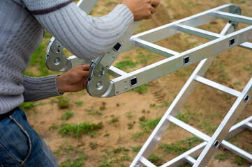 worker arranging expandable ladder