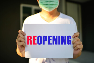Reopen economy concept after the coronavirus pandemic.with man holding a paper with a message...