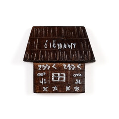 Magnetic souvenir from Slovakia with the image of a black wooden house in the village of Tchitchmany isolated on white background. The inscription on the magnet Slovak village name means 