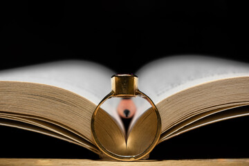 old book and a golden ring and a wooden pencil