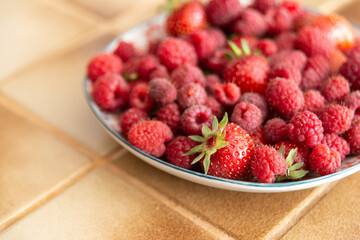 Assiette de fraises et de framboises fraîches dans une cuisine