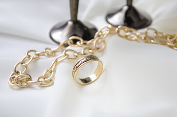 Gold ring with chain on a white background. Side light.