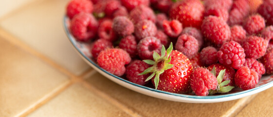 Bannière d'une assiette de fraises et de framboises fraîches dans une cuisine