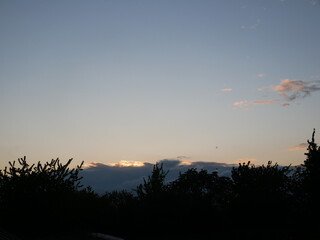 Coucher de soleil parmi les nuages et les arbres 