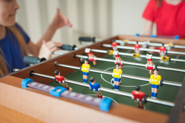 Children play table football in a children's room, close-up