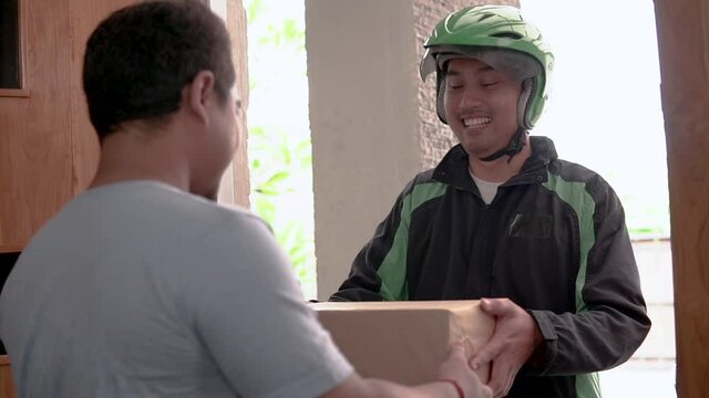 uber driver courier delivering package box to a man in his house