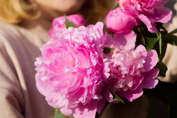 Faceless woman holding bouquet of pink peony. Flowers for celebrate. Valentine's day.
