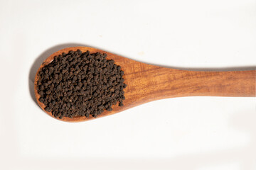 Dried Tea Leaves powder on Spoon With White Background