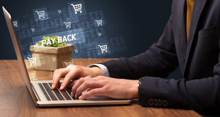 Naklejka na ściany i meble Businessman working on laptop with PAY BACK inscription, online shopping concept
