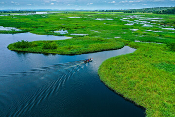 Dramatic landscape from above by the river, boat crossing in the wild African landscapes of Angola - obrazy, fototapety, plakaty