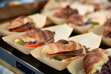 croissant with meat, tomato and pickles