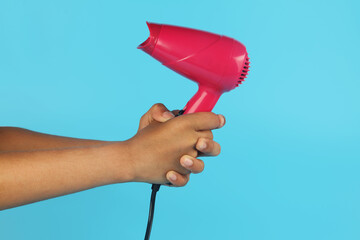 Hand holding a new pink color hairdryer 