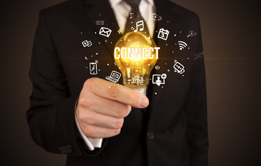 Businessman holding light bulb with CONNECT inscription, social media concept