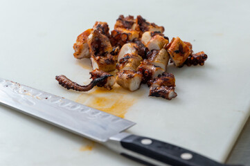 chopped octopus for cooking with chef's knife on the side