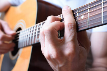 Detail of man playing acoustic guitar