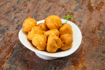 Sweet tasty profiteroles heap in the bowl