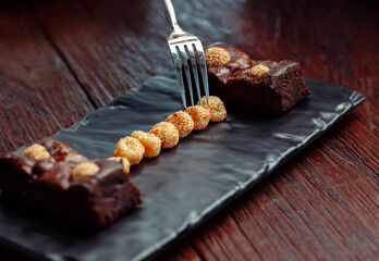 Chocolate brownies with sesame balls or Klepon, Kelepon, Onde Onde- traditional Southeast Asian rice cake balls. Asian modern dessert