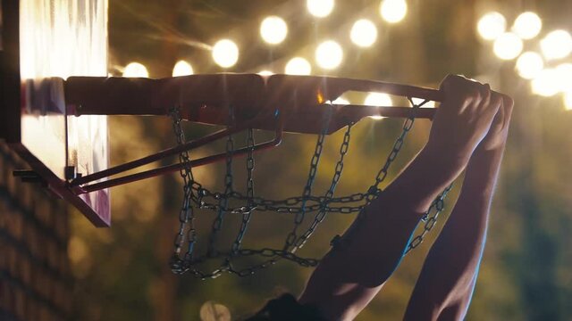 Basketball ball getting in the hoop on playground at night - slam dunk