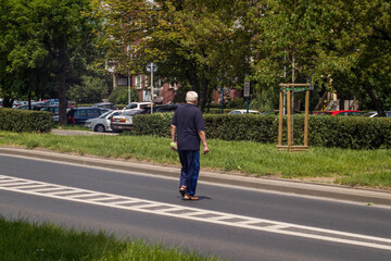 Wroclaw, Poland, June 12, 2020, old man crossing a street in prohibited place, jay walking