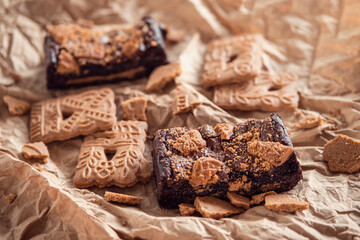 Delicious chocolate brownies with speculaas biscuits on rustic background. Chocolate dessert aesthetics