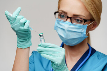 medical doctor nurse woman wearing protective mask and gloves - holding syringe