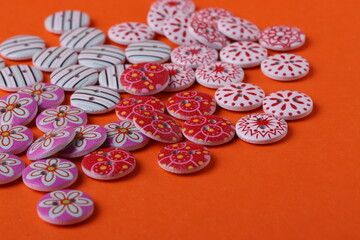 colorful buttons made of wood for sewing or handmade on an orange bright background