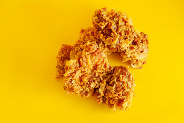 Crispy fried chicken against a bright yellow background