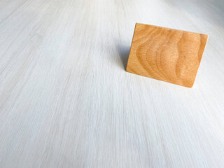 A sign made of brown alder wood is placed on a white wooden table in the upper right corner. In a cafe, a coffee shop with copy space. cafe business.