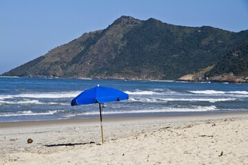 Seascape of a beach and an umbrella in Ãrea de ProteÃ§Ã£o Ambiental Bairro de Grumari Rio Brazil