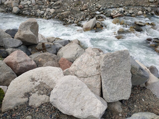 Stone on the background of a stormy river