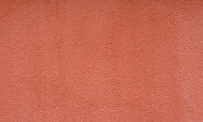 Peach color textured concrete wall of the house. Decorative plaster. Abstract background