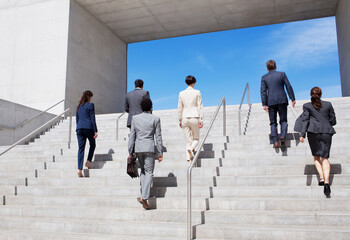 Business people ascending urban stairs