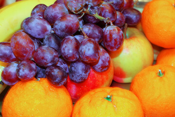 Naklejka na ściany i meble Grapes, apples, tangerines and banana. Background of different fruits