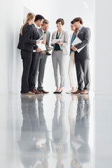 Business people with paperwork meeting in corridor