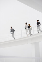 Business people running down elevated walkway