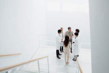 Business people and doctors on landing of stairs