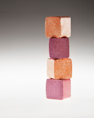 Close up of stacked gold and pink eyeshadow cubes