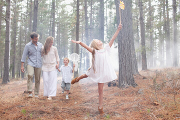 Happy family with butterfly nets in sunny woods