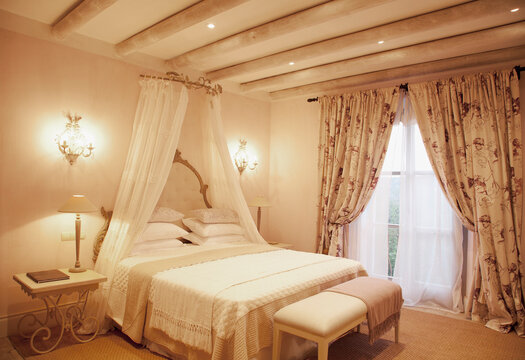 Sconces and canopy above bed in luxury bedroom