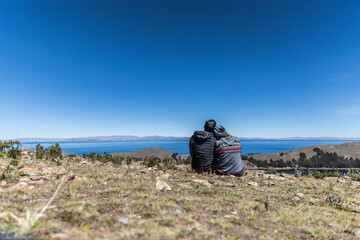 Fototapeta premium Couple sitting together by a huge lake