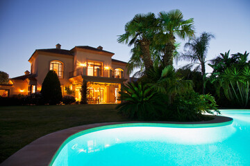 Luxury swimming pool and villa illuminated at night
