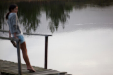 Fototapeta na wymiar Woman standing on dock over lake