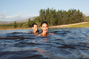 Portrait of smiling couple swimming in lake