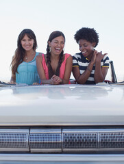 Smiling women sitting in convertible