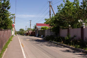 Fototapeta na wymiar street in the village in summer with a blue sky