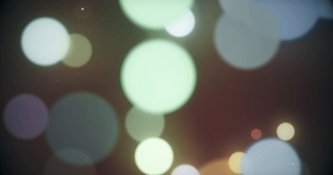 Colorful defocused particles bokeh with a blurred depth of field. Multi-colored bokeh moving floating particle animation. Seamless Loop.