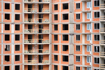 Windowless high-rise brick house under construction.