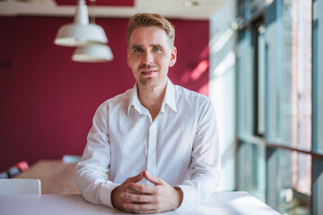 Businessman with clasped hands, looking at camera