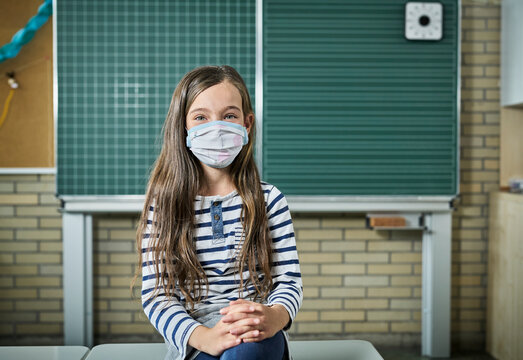 Portrait Of Girl Wearing Mask In Classroom